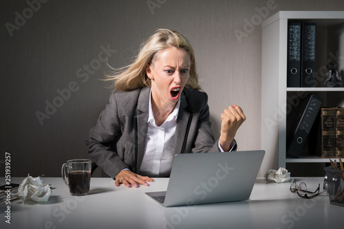 Woman angry at her laptop computer at work photo