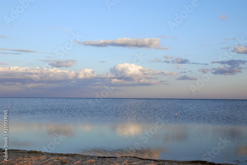 reflection of clouds in the calm sea in the evening at sunset