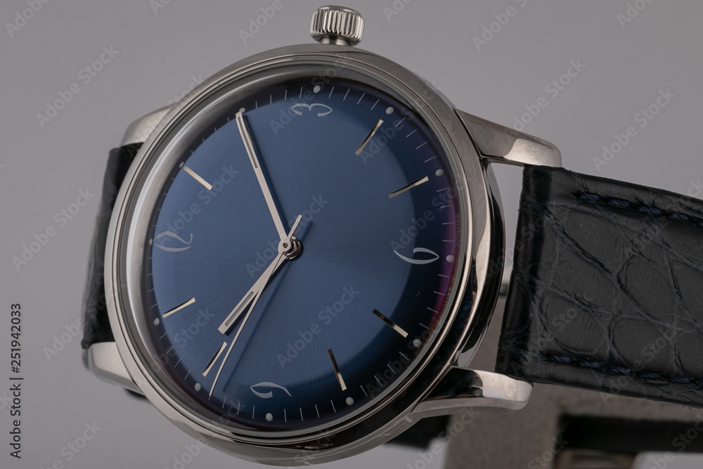 Men's watch with black leather strap,blue dial, in silver body,gray clockwise and numerals isolated on gray background. Men's watch with black leather strap,blue dial, in silver body,gray clockwise and numerals isolated on gray background.