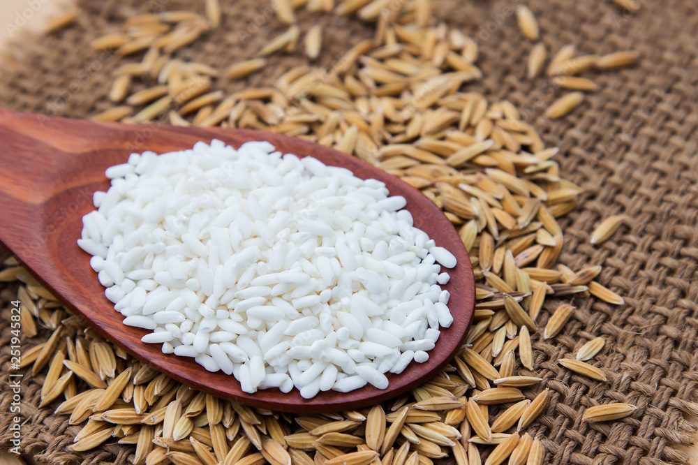 Raw peeling paddy rice on wooden table Raw peeling paddy rice on wooden table