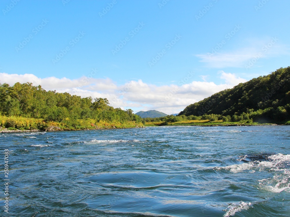 Beautiful Bystraya Malkinskaya river flows in valley between hills on the Kamchatka Peninsula, Russia.