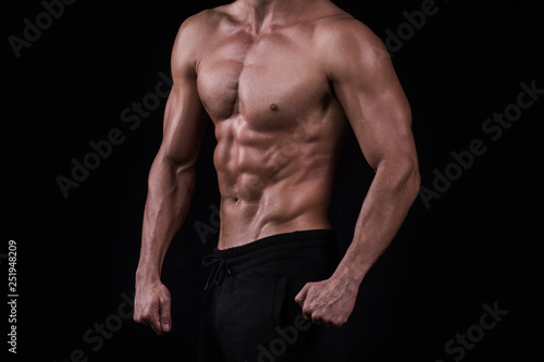  Fit young man's torso. Muscular torso of slim fitness sporty man. Studio lighting, dark background
