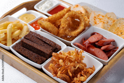 beer snacks of fried bread, onion rings and shrimps with sauce