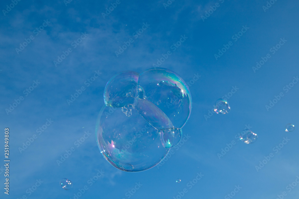 Soap bubbles in the air isolated on the blue sky 