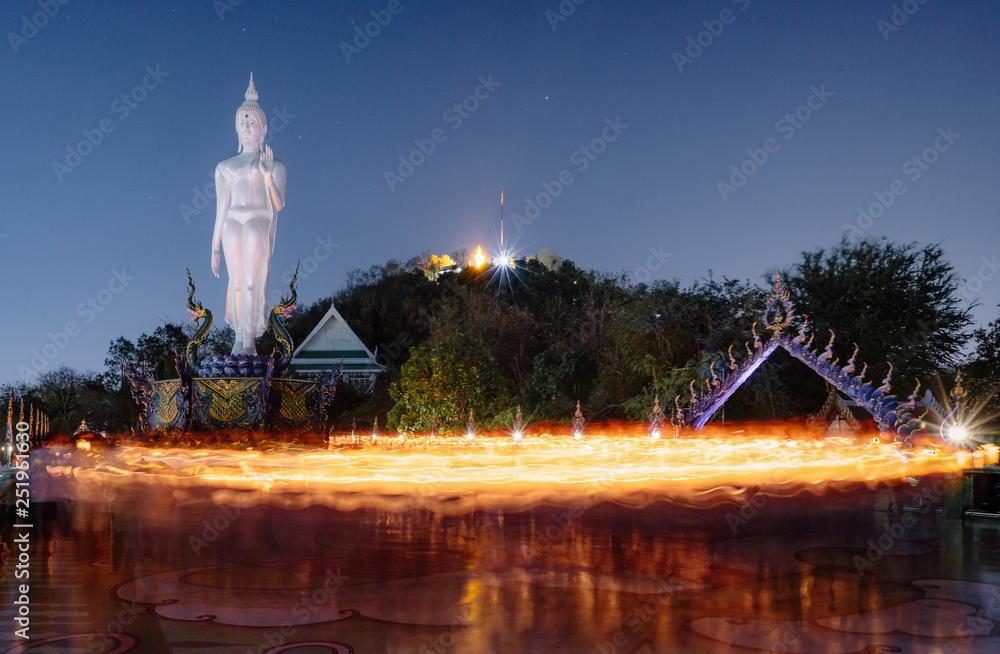 Fototapeta premium The candle lit ceremony around the Buddha image, Makha Bucha Day.