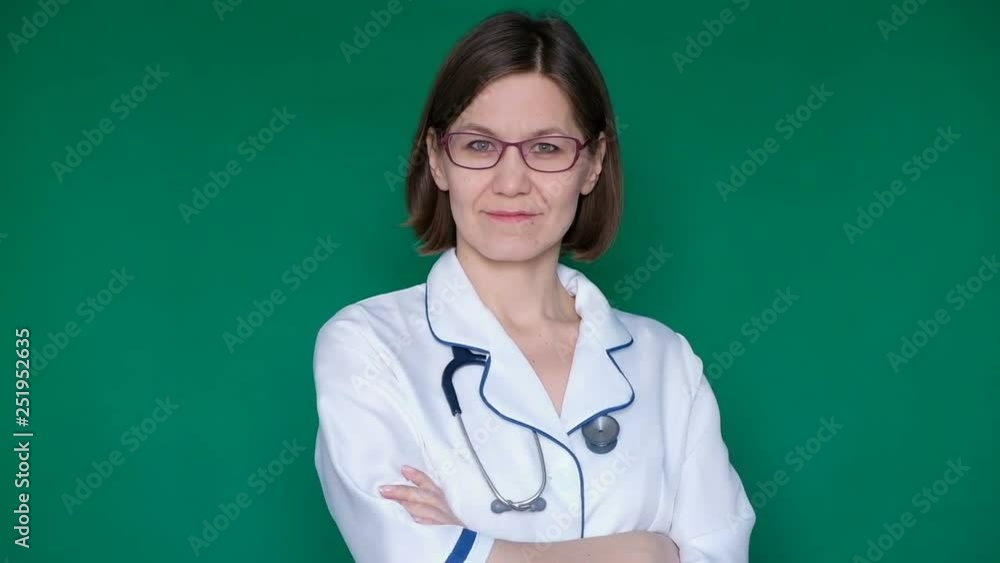 Smiling confident woman doctor in lab coat looking at the camera on a Green Screen, Chroma Key. Close up Smiling confident woman doctor in lab coat looking at the camera on a Green Screen, Chroma Key. Close up
