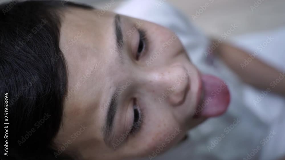 Angina, Mom Applies Medical Sprayer, child opens his mouth, Inhalation spray for treatment of sore throat, little boy is sick, child with scarf around his neck, painful kind Angina, Mom Applies Medical Sprayer, child opens his mouth, Inhalation spray for treatment of sore throat, little boy is sick, child with scarf around his neck, painful kind