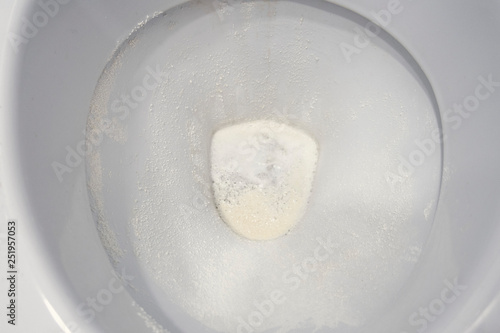 Toilet bowl sprinkled with detergent powder, close-up