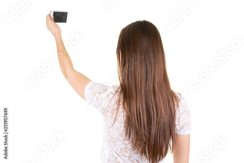 Back view of young teenager fit woman taking photo with smartphone portrait isolated on white background