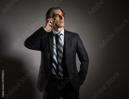 Businessman in a stylish suit calls on a mobile phone. © papa