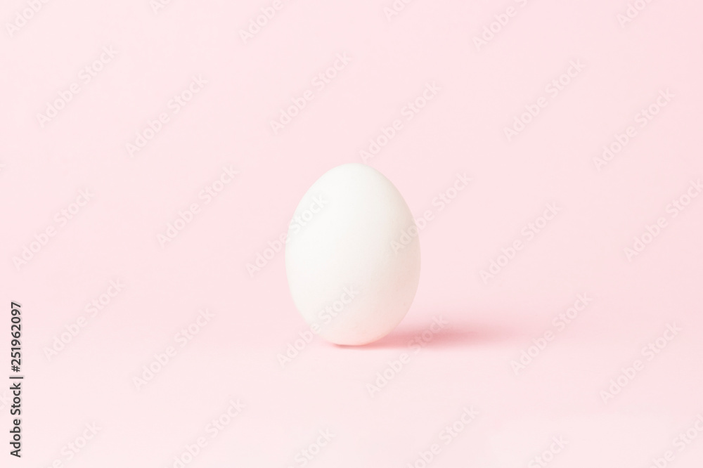 White Chicken Egg on a pink background. Minimalism. Side view