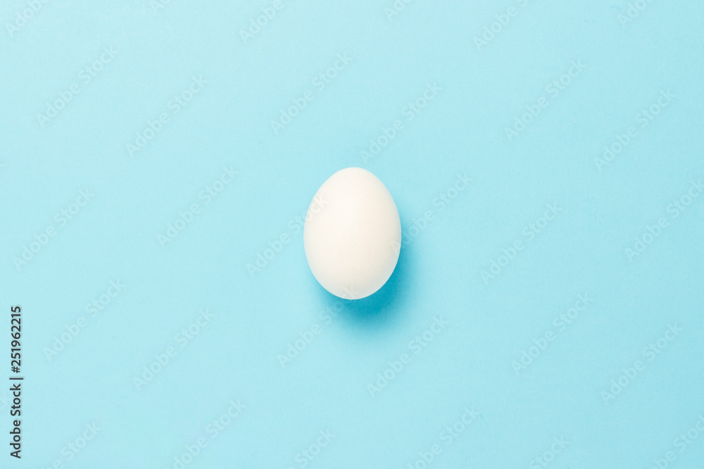 White Chicken Egg on a blue background. Minimalism. Flat lay, top view White Chicken Egg on a blue background. Minimalism. Flat lay, top view