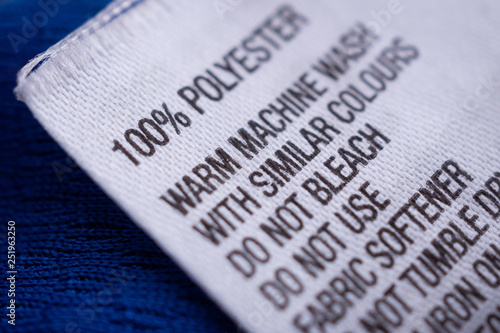 Polyester clothing label with laundry care instructions tag on blue shirt jersey