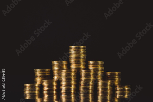 Increasing columns of coins, step of stacks coin on dark background with copy space for business and financial concept.