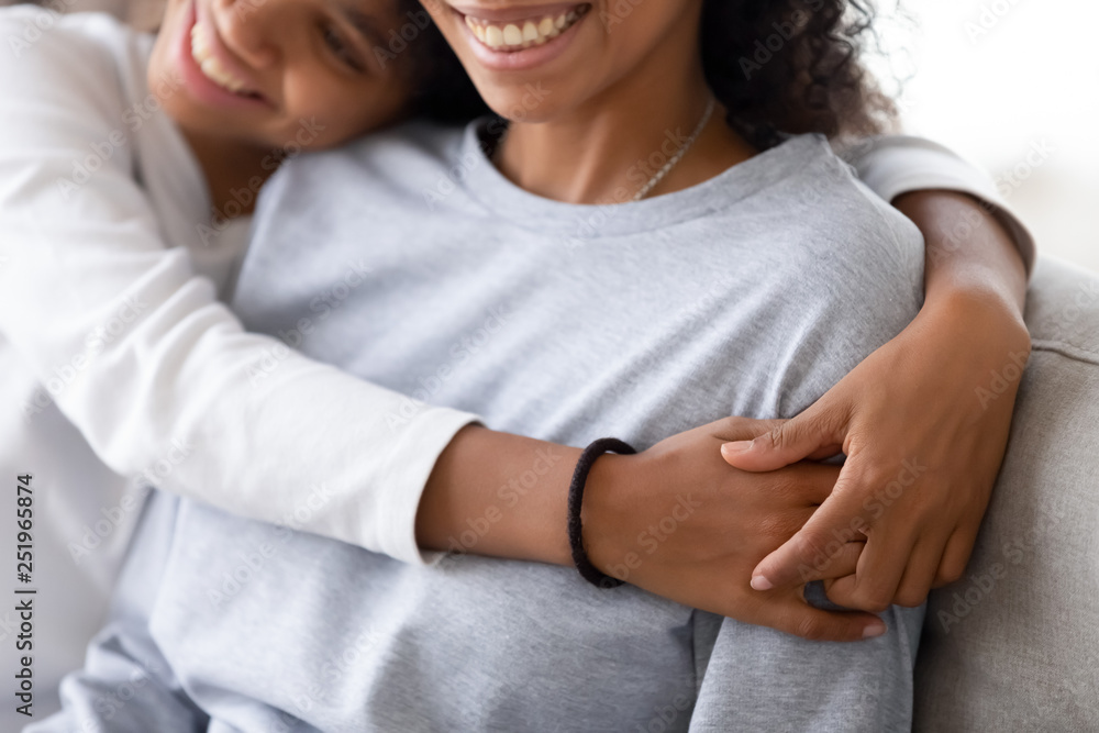 Fototapeta premium Cropped image of african daughter embracing mother