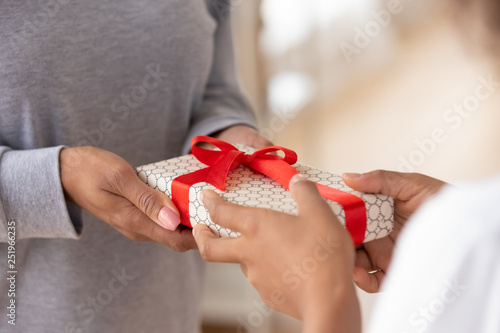 Close up of women hands holding one gift box