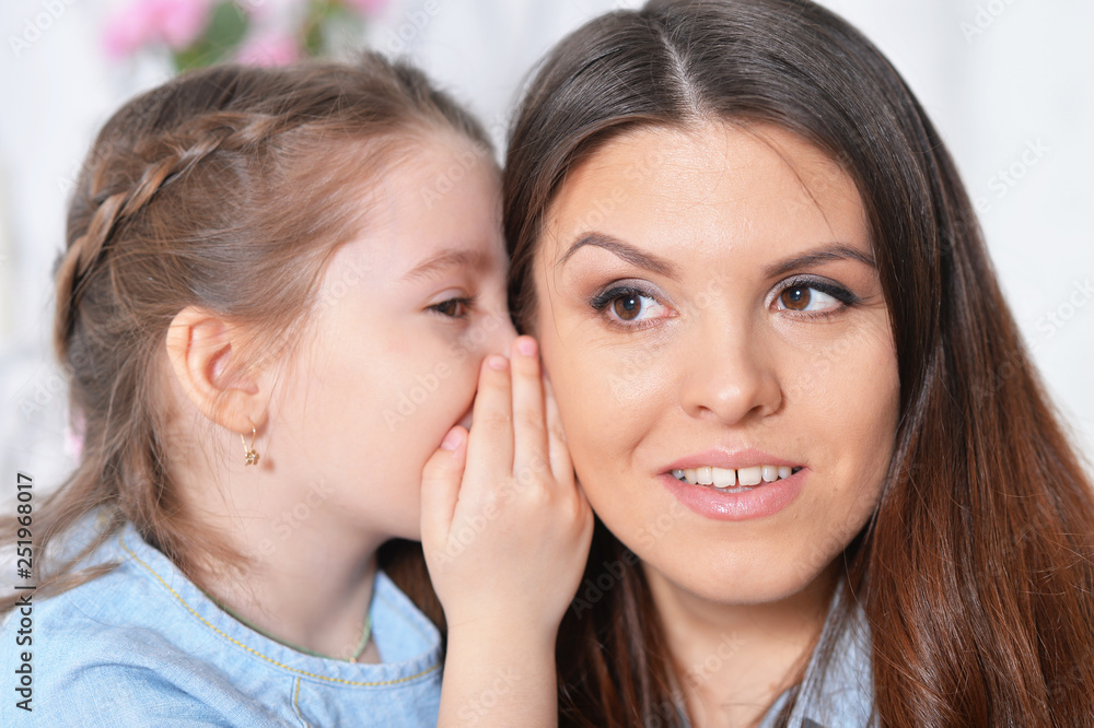 Close up portrait of little girl with mother hugging Close up portrait of little girl with mother hugging