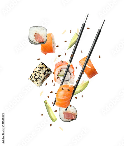 Tasty sushi rolls, avocado and chopsticks on white background photo