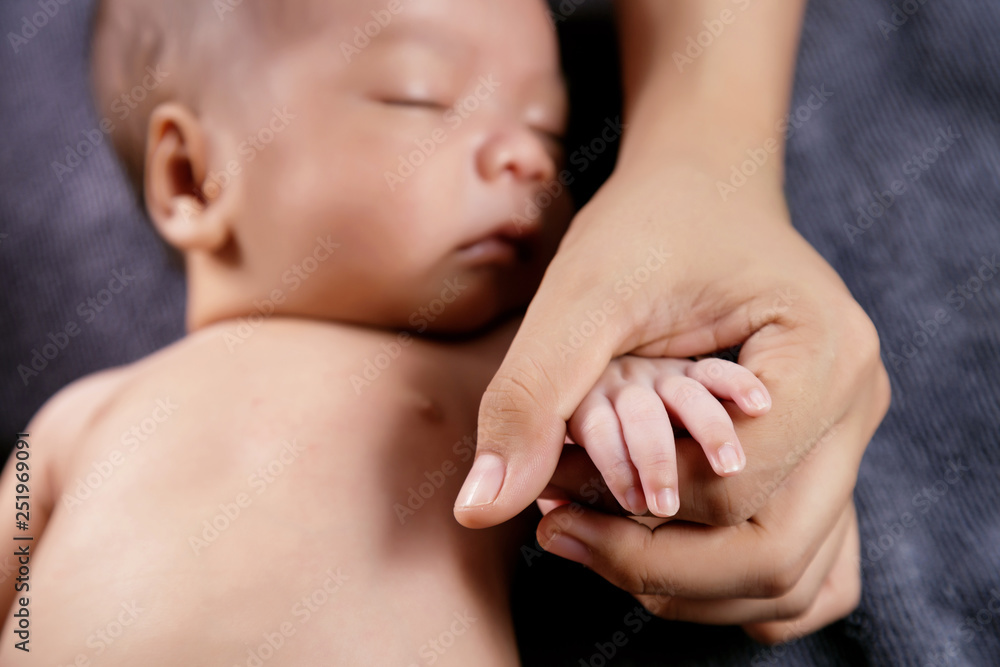 Parent holding hand of newborn baby in the hands Parent holding hand of newborn baby in the hands