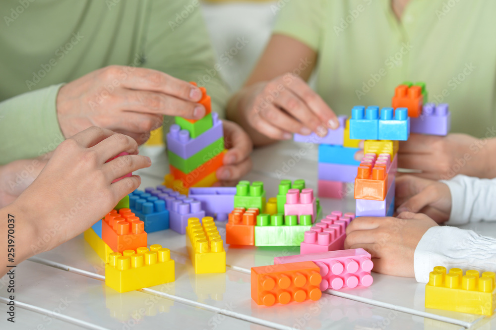Parents and children playing with colorful plastic blocks Parents and children playing with colorful plastic blocks