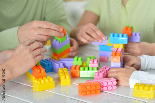 Parents and children playing with colorful plastic blocks