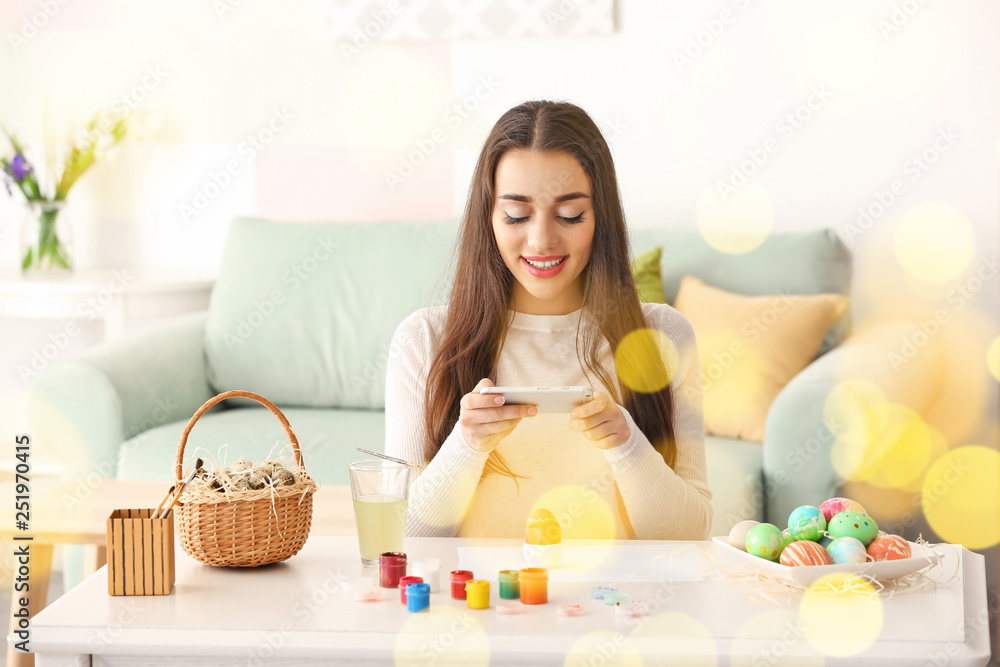 Beautiful young woman taking photo of painted Easter eggs at home Beautiful young woman taking photo of painted Easter eggs at home