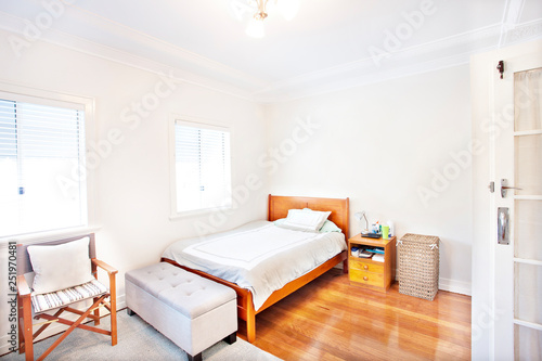 Single white bedroom with polished wood floor