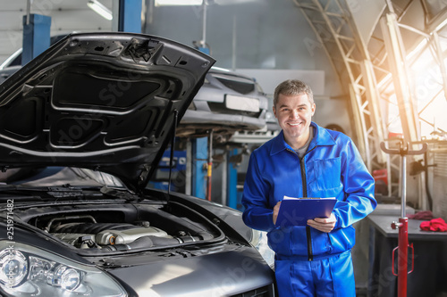 Male mechanic with clipboar...