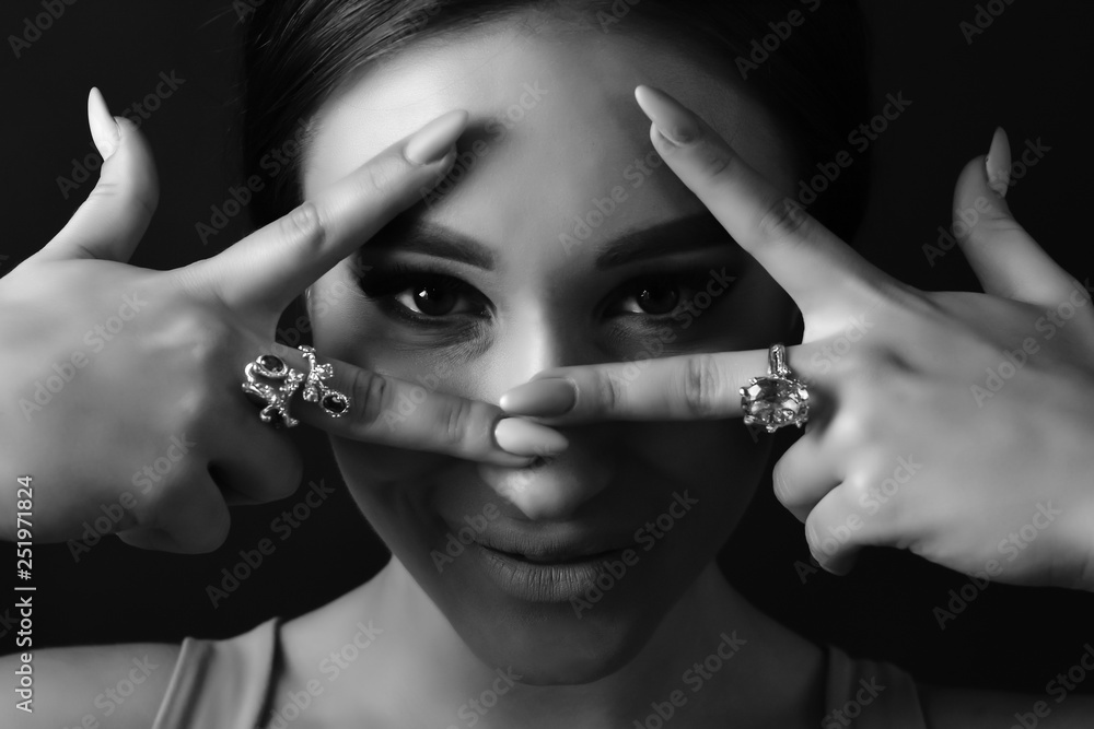 Obraz premium Beautiful girl model shows hands with jewelry. Close up. Beautiful eye. Brunette. Black and white photo