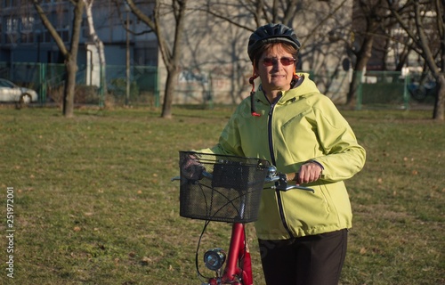 Portrait of the senior woman with the red city bike
