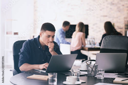 Young man using laptop to get ready for business meeting in office