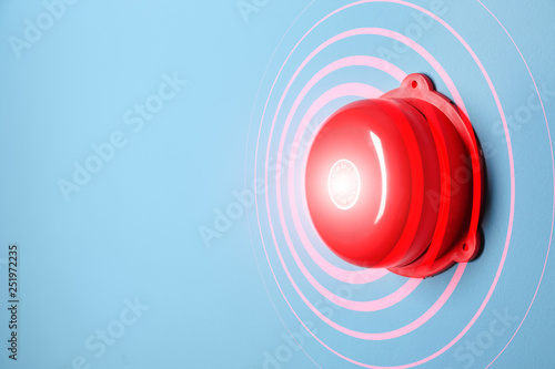 Modern alarm bell on color background photo