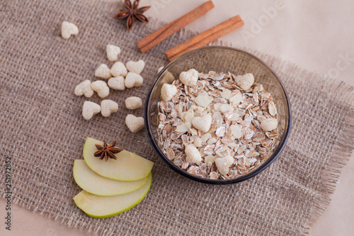 Healthy food. Muesli in a bowl on a light background with a green apple. Breakfast porridge on linen background