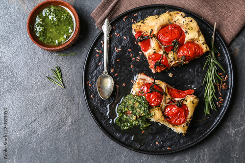 Tasty Italian focaccia and basil sauce on grey table photo