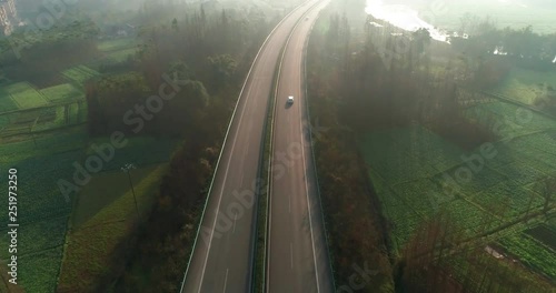 Aerial Drone Footage View: landscape of countryside,cars running on the highway in the ealry spring morning, fields and trees in the mist, river flows quietly along the high road,,in Sichuan China,4K photo