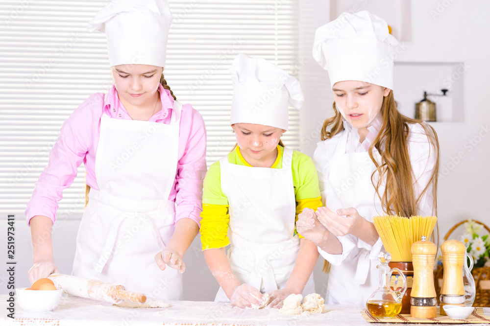 Portrait of three cute girls cooking on kitchen Portrait of three cute girls cooking on kitchen