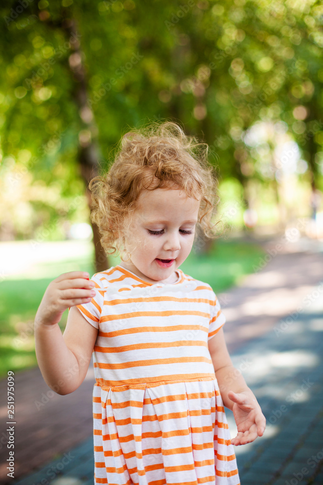 Little blonde curly girl blowing soap bubbles in summer park Little blonde curly girl blowing soap bubbles in summer park