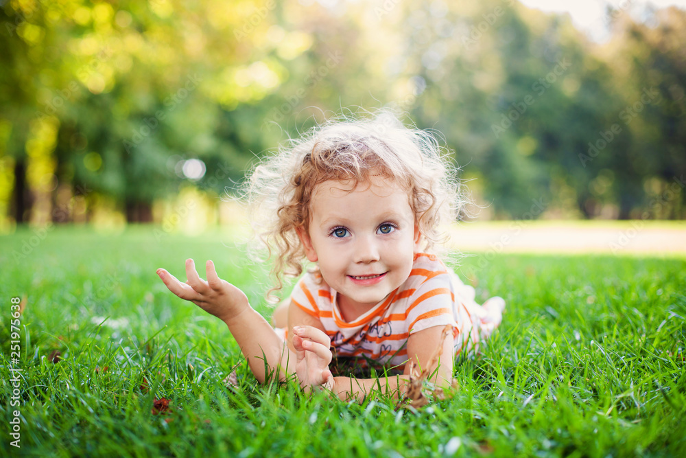 Beautiful blonde curle girl outside in a field with sunlight on her hair Beautiful blonde curle girl outside in a field with sunlight on her hair