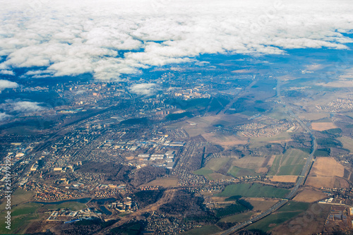 view of the city, land, sky and clouds from the airplane window