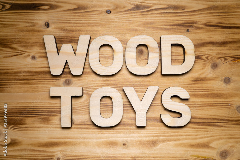 WOOD TOYS words made of wooden block letters on wooden board, top view. WOOD TOYS words made of wooden block letters on wooden board, top view.