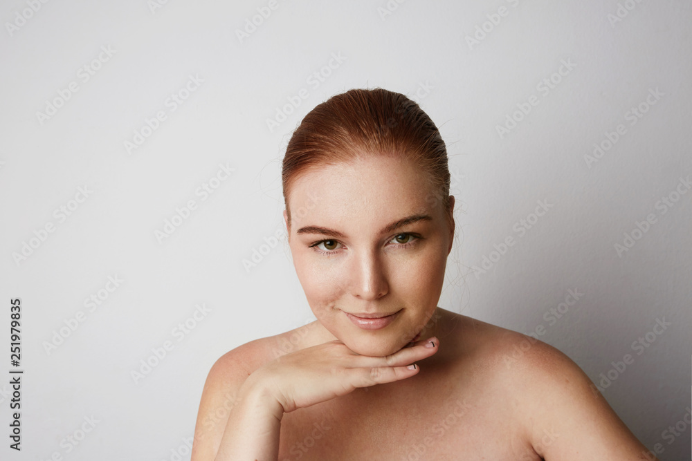 Profile portrait of beauty female redhead model with happy smiling and light nude make-up. Background Profile portrait of beauty female redhead model with happy smiling and light nude make-up. Background