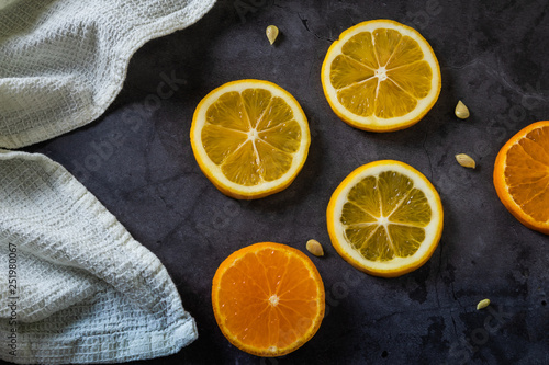 Fototapeta Naklejka Na Ścianę i Meble -  Slices of lemon and mandarin on a dark background
