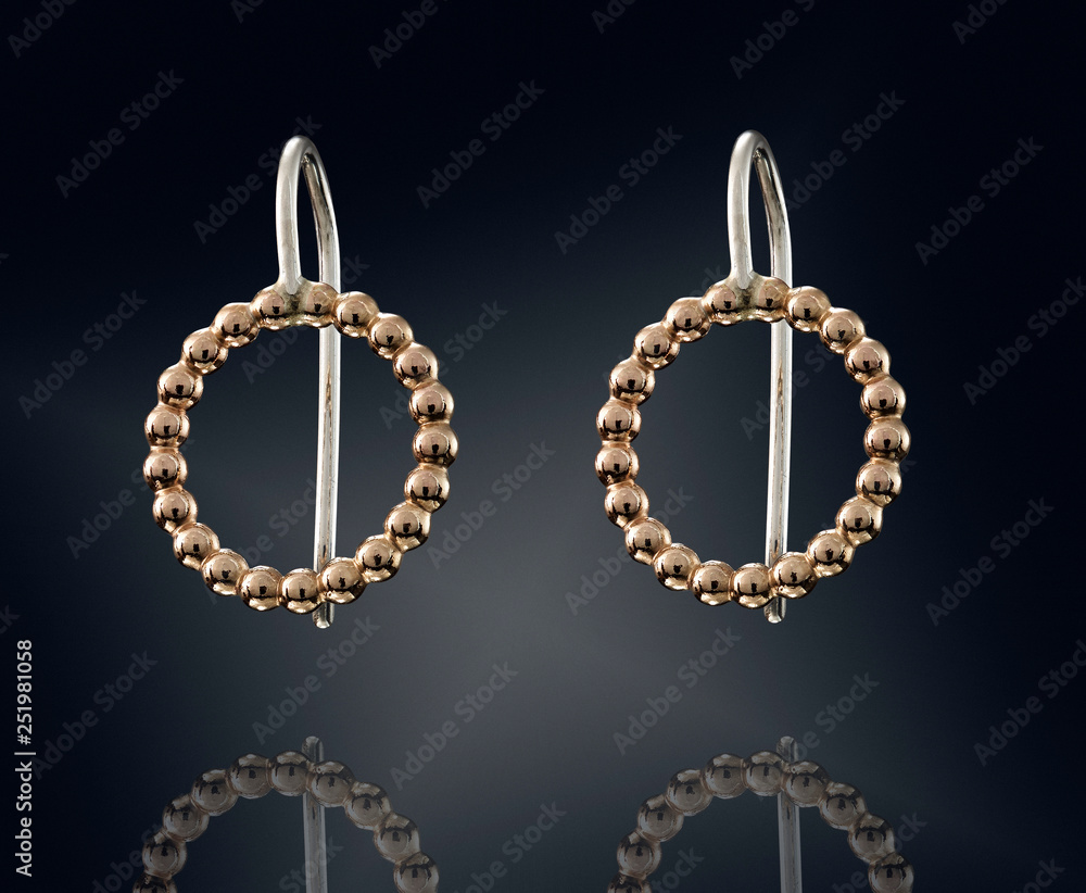 Golden earrings isolated on black background Golden earrings isolated on black background