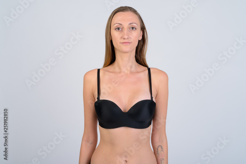 Portrait of blonde woman in bikini against white background © Ranta Images