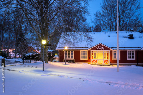 Winter scenery with red wooden house in Sweden at night