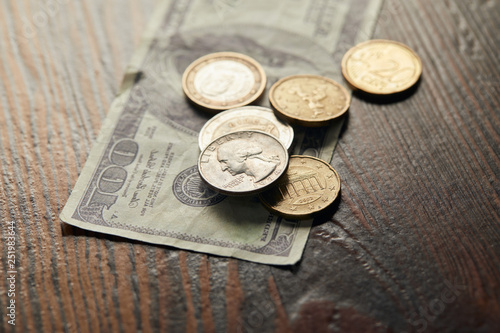 selective focus of dollar banknote and coins on wooden surface
