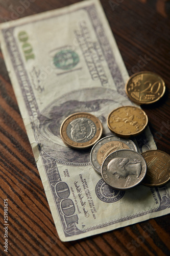 selective focus of dollar banknote and coins on wooden table