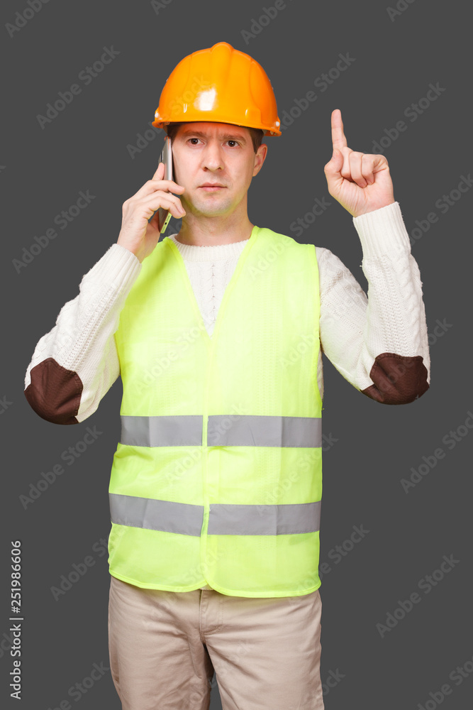 the man in a helmet speaks by phone, points a finger up