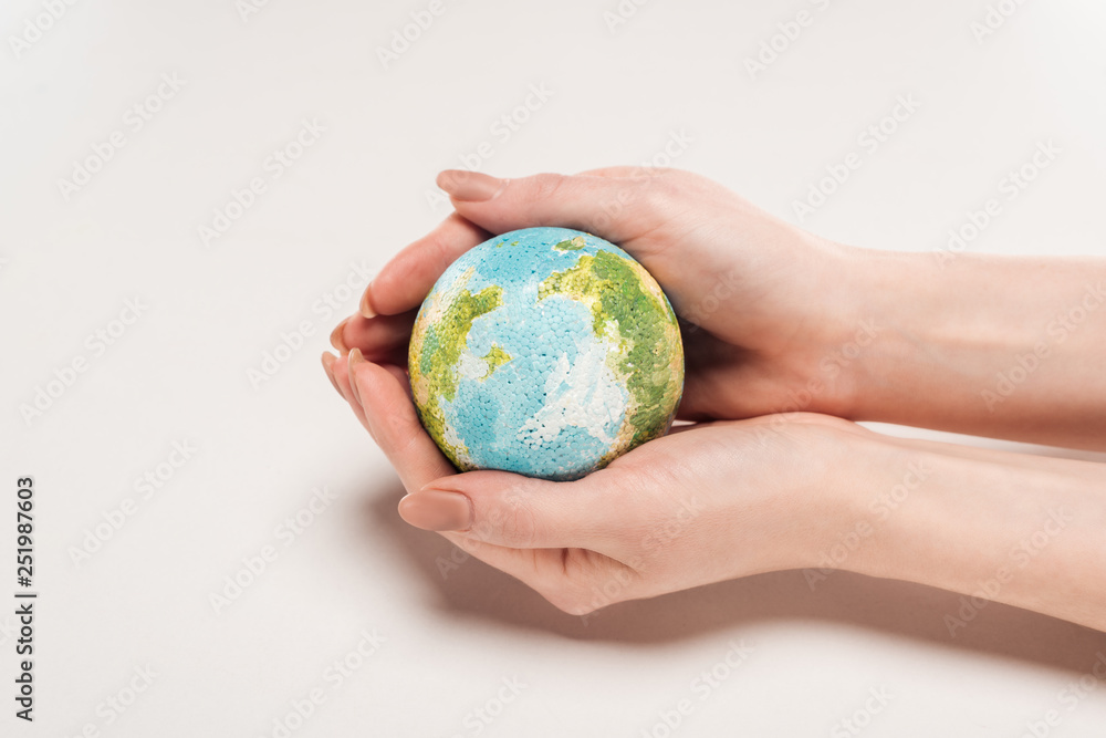 cropped view of woman holding earth model on white background, global warming concept cropped view of woman holding earth model on white background, global warming concept
