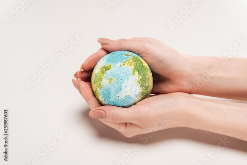 cropped view of woman holding earth model on white background, global warming concept